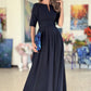 Long dark blue dress with pleats. Golden color detail in neckline