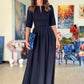 Long dark blue dress with pleats. Golden color detail in neckline